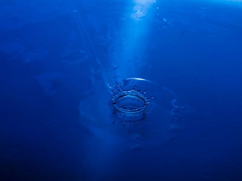 Person in a fluid motion pose against a dark, calm background.